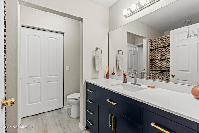 bathroom featuring vanity, toilet, and hardwood / wood-style floors