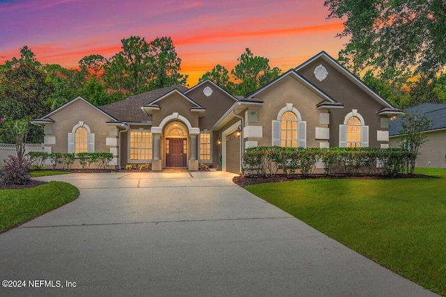 view of front of house featuring a garage and a lawn