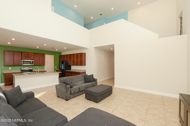 tiled living room featuring a towering ceiling and sink