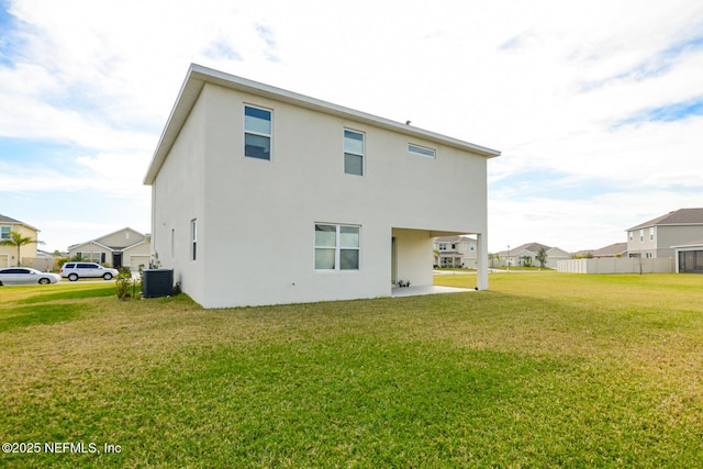 rear view of house featuring a yard and central air condition unit