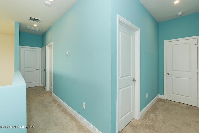 hallway featuring light colored carpet