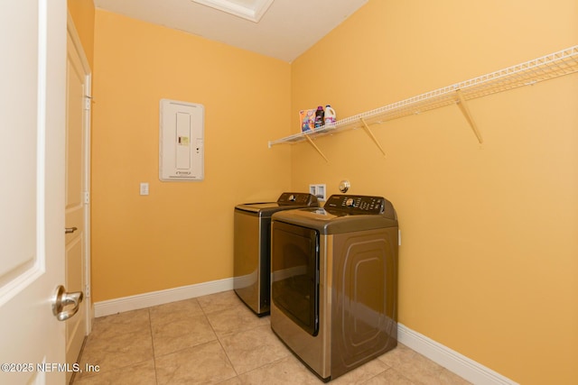 laundry area with light tile patterned flooring, electric panel, and washing machine and dryer