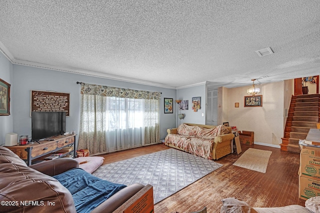 living room with hardwood / wood-style flooring, ornamental molding, and a textured ceiling