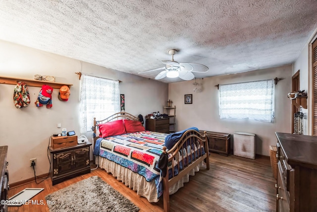 bedroom with hardwood / wood-style floors, a textured ceiling, and ceiling fan