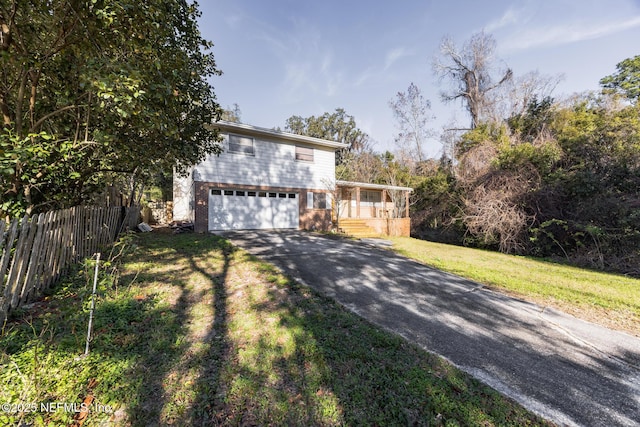 view of property featuring a garage, a front lawn, and a porch