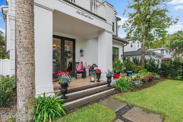 property entrance with a yard and french doors