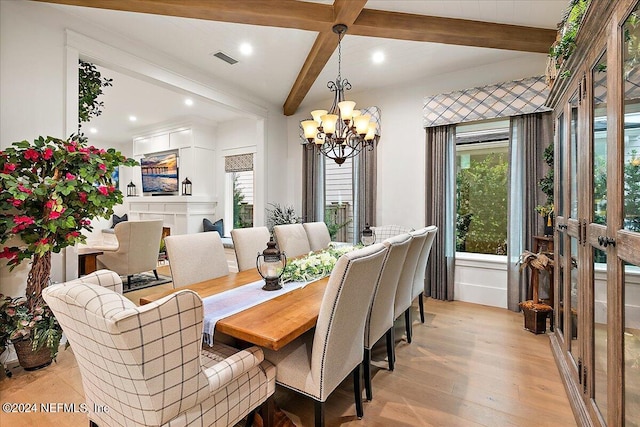 dining room with a notable chandelier, beam ceiling, and light hardwood / wood-style floors