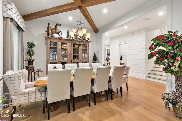 dining space featuring beamed ceiling, light hardwood / wood-style floors, and a notable chandelier