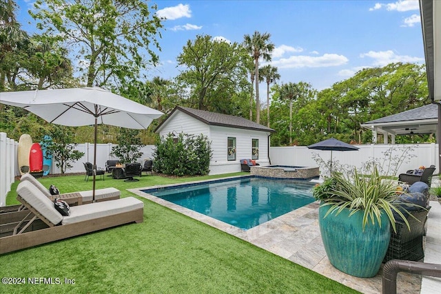 view of swimming pool featuring a yard, an outbuilding, and an in ground hot tub