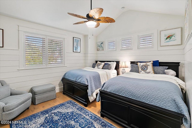 bedroom with multiple windows, wood-type flooring, ceiling fan, and vaulted ceiling