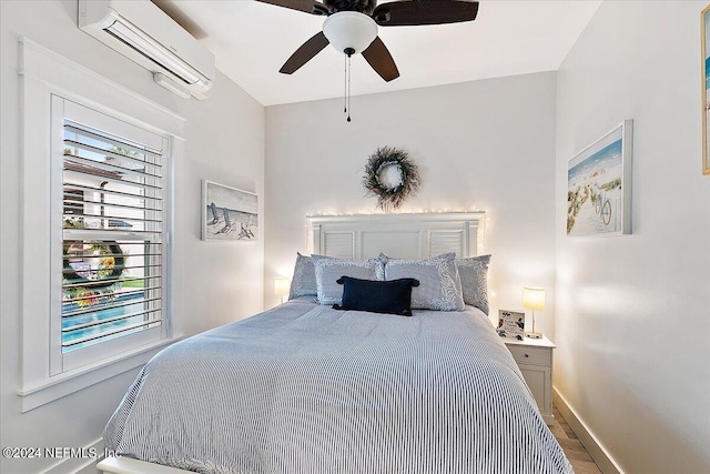 bedroom featuring hardwood / wood-style floors, a wall unit AC, and ceiling fan