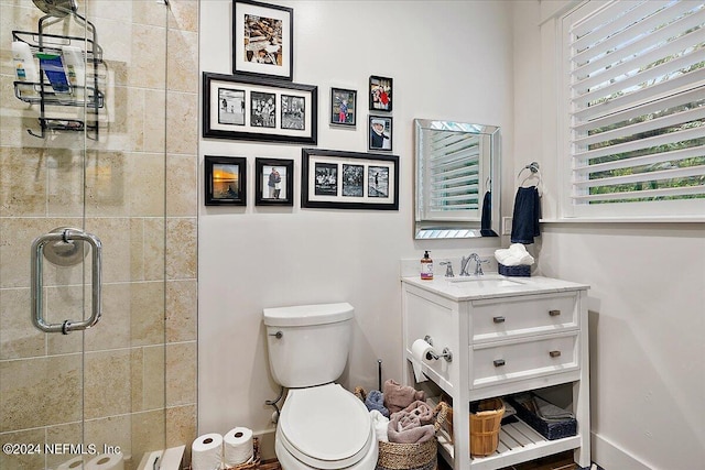 bathroom with vanity, toilet, a shower with shower door, and a baseboard heating unit