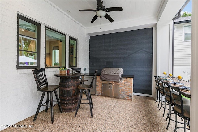 view of patio / terrace featuring ceiling fan, exterior bar, and exterior kitchen