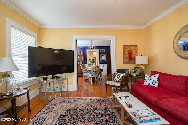 living room with crown molding, wood-type flooring, and a notable chandelier