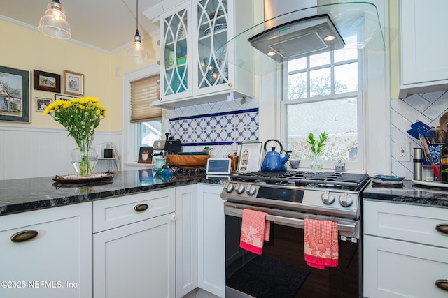 kitchen featuring stainless steel gas range, crown molding, decorative light fixtures, dark stone counters, and white cabinets