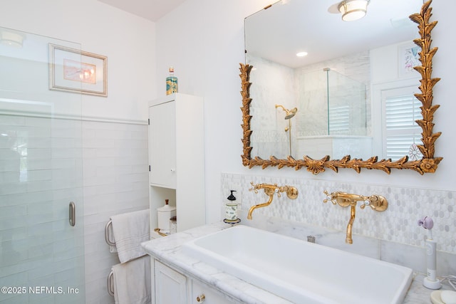 bathroom with a shower with door and sink