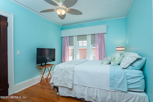 bedroom featuring ceiling fan, ornamental molding, and wood-type flooring