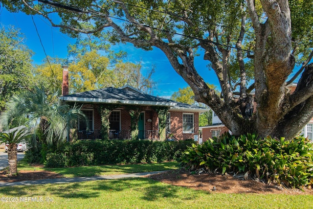 view of front of property featuring covered porch and a front lawn