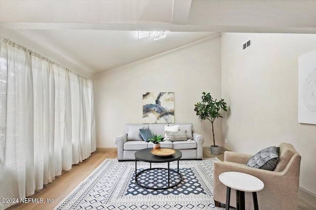 living room featuring wood-type flooring and vaulted ceiling