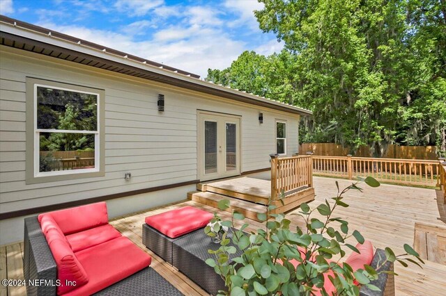 wooden terrace with french doors and an outdoor hangout area