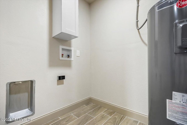 laundry room featuring water heater, washer hookup, and cabinets