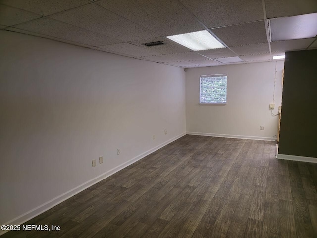 unfurnished room featuring a paneled ceiling and dark hardwood / wood-style flooring