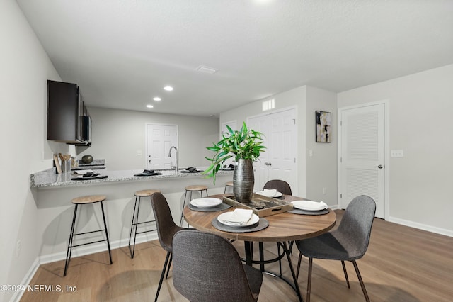 dining area featuring sink and light hardwood / wood-style floors