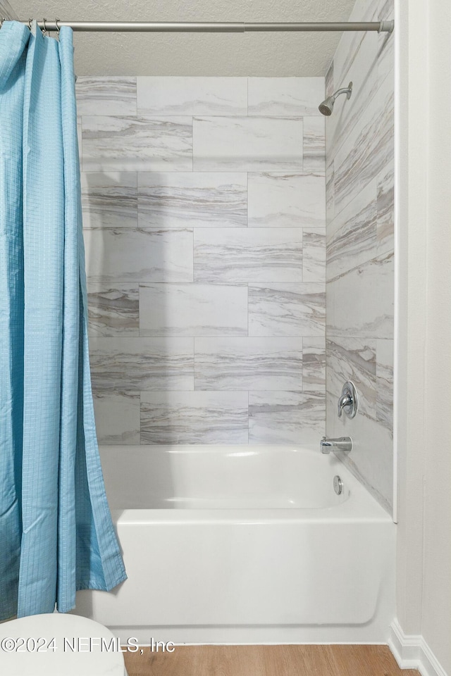 bathroom with hardwood / wood-style flooring and shower / bath combo