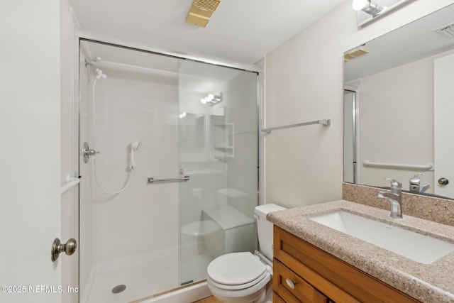 bathroom with a shower with door, vanity, and toilet