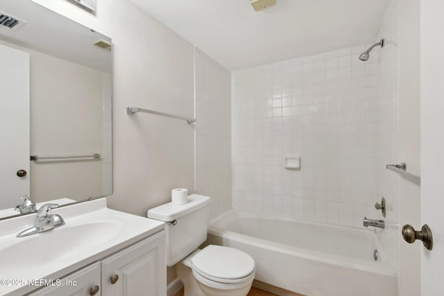 full bathroom featuring tiled shower / bath, vanity, and toilet