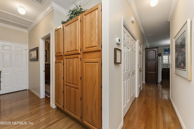 corridor with hardwood / wood-style flooring and ornamental molding