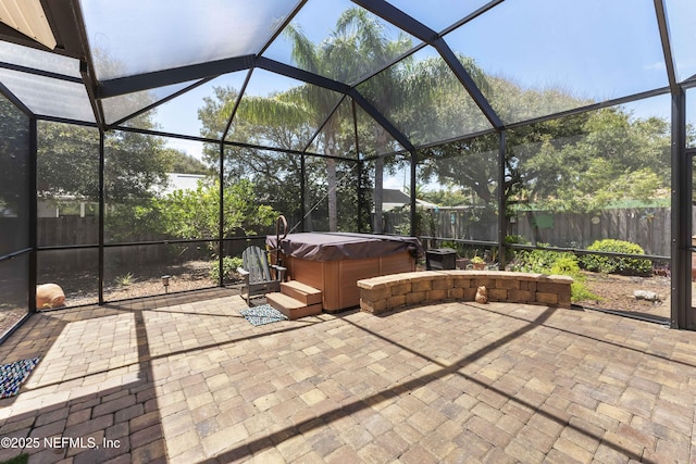 view of patio / terrace with a hot tub and glass enclosure