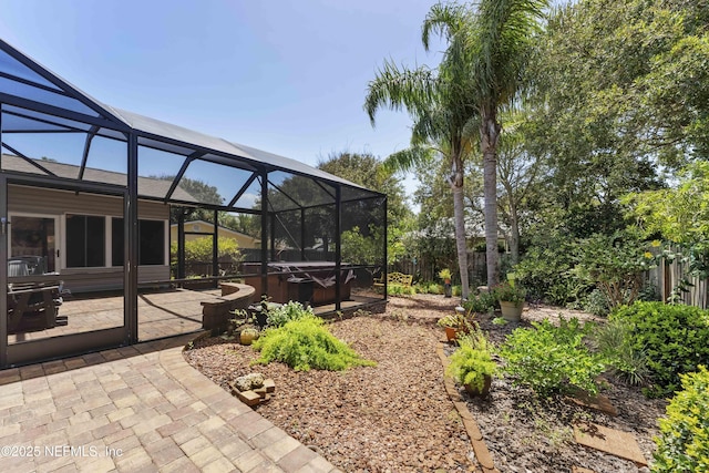 view of yard featuring a patio area, a hot tub, and glass enclosure