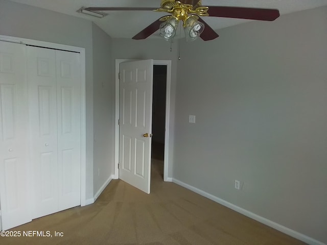 unfurnished bedroom featuring light carpet, ceiling fan, and a closet