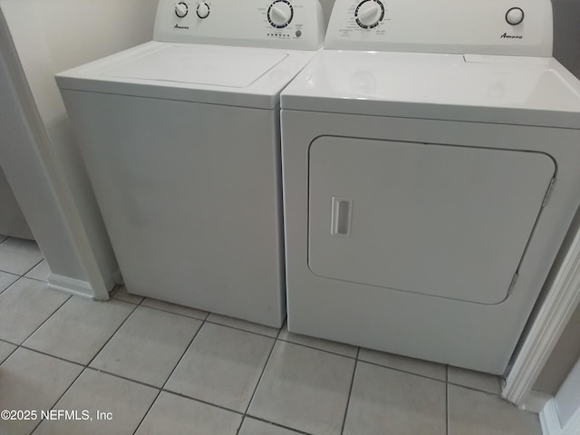 laundry room featuring washing machine and clothes dryer and light tile patterned floors