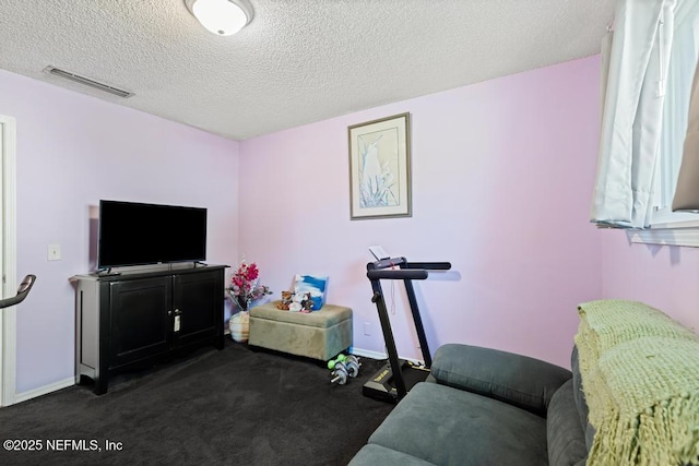 interior space featuring a textured ceiling and dark colored carpet