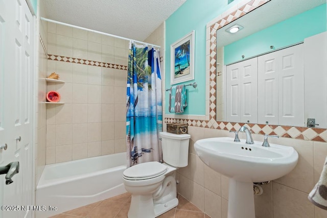 bathroom featuring tile walls, toilet, shower / bath combo, tile patterned floors, and a textured ceiling