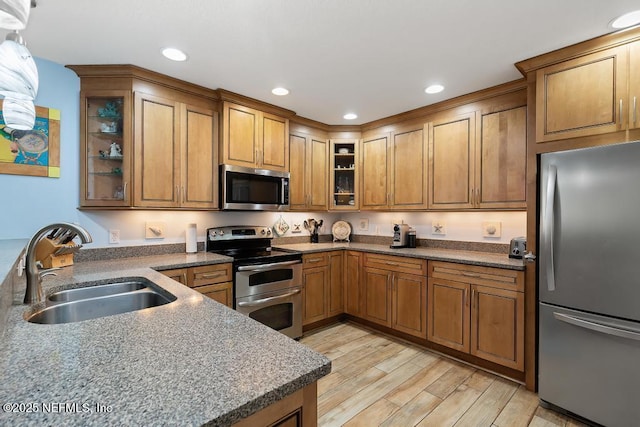 kitchen with sink, stainless steel appliances, and light hardwood / wood-style floors