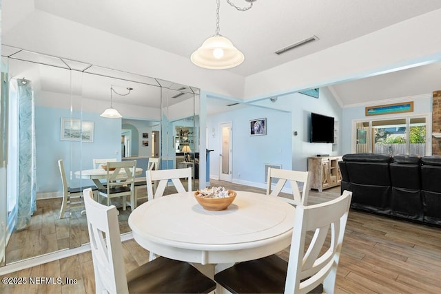 dining area with lofted ceiling and wood-type flooring