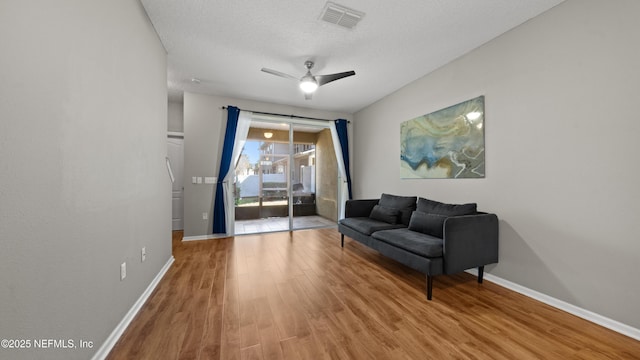 sitting room with ceiling fan, light hardwood / wood-style floors, and a textured ceiling