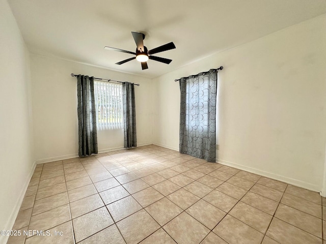 tiled spare room featuring ceiling fan