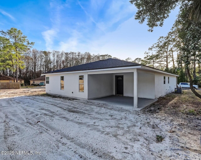 back of house featuring a carport