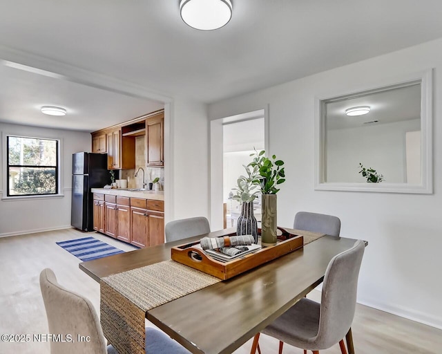 dining area featuring sink and light hardwood / wood-style flooring