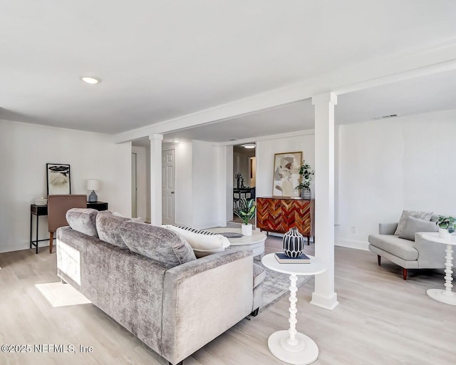 living room with decorative columns and light wood-type flooring