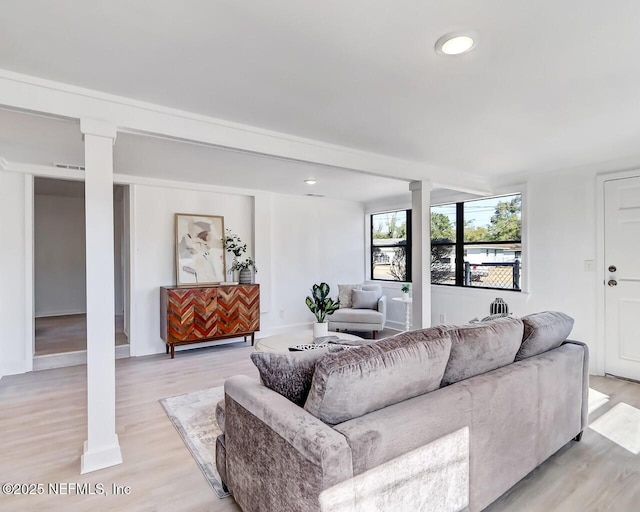 living room with decorative columns and light wood-type flooring