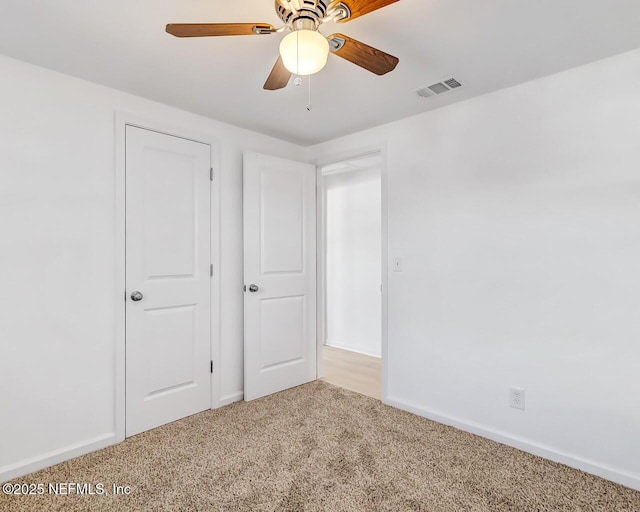 unfurnished bedroom featuring light colored carpet and ceiling fan