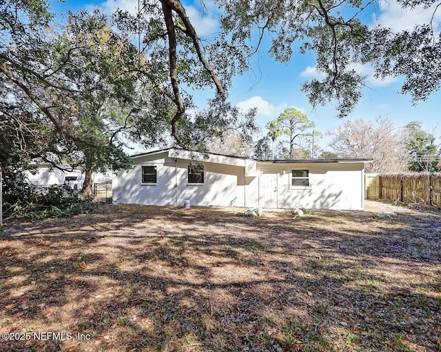 rear view of property featuring a lawn