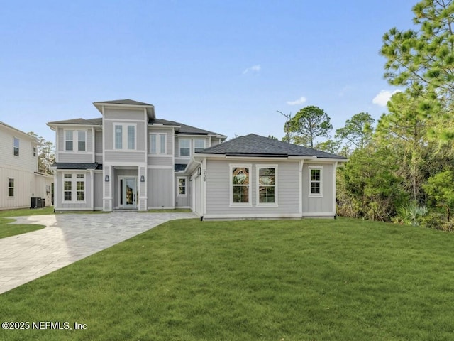 view of front of home with cooling unit and a front yard