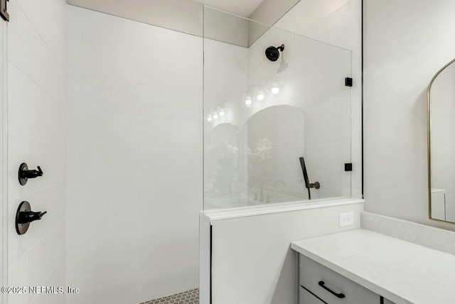 bathroom with vanity and tiled shower