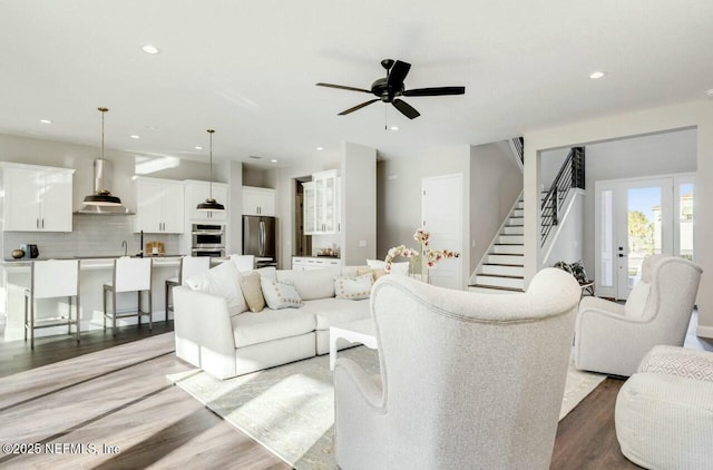 living room featuring ceiling fan and light hardwood / wood-style floors